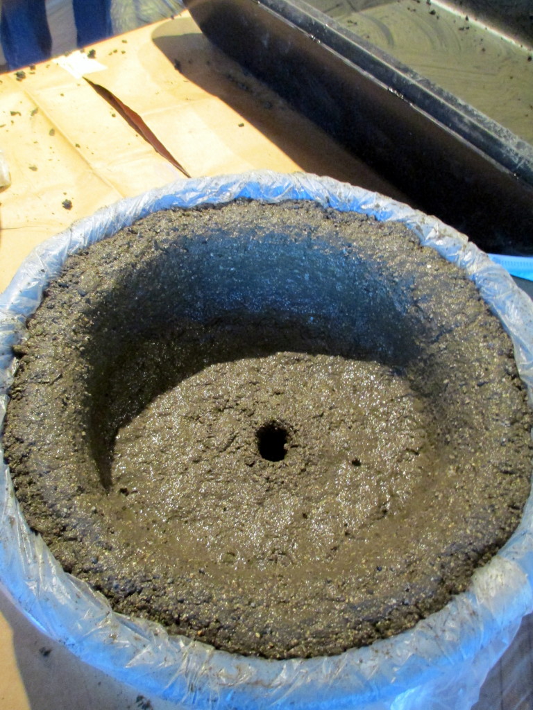 Step #  ~ Pat the wet hypertufa mixture firmly onto the bottom and sides of the container. Make a drainage hole in the bottom too!