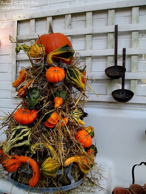 Gourd Tower ~ hay & gourds fill a metal bottle rack https://lolajack-global.jp.net/autumn-garden-accents-inside-and-out/